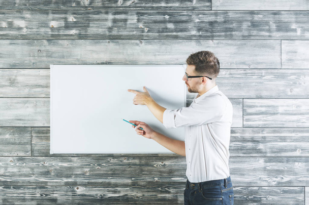 Attractive man pointing at whiteboard  - Foto, afbeelding