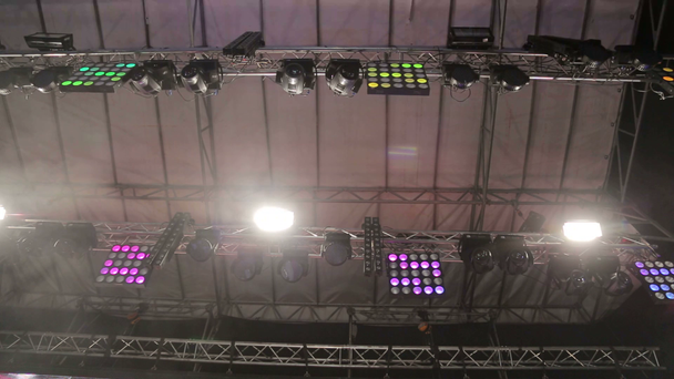 Verlichting van de grote scène. Knipperende lampen in verschillende kleuren bewegen in verschillende richtingen. Licht aan concerten, disco's, nachtclubs. - Video