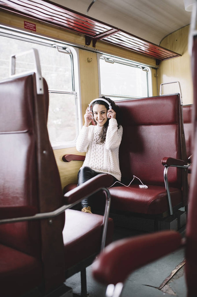 Teen passenger listening to the music traveling in a train - Fotó, kép