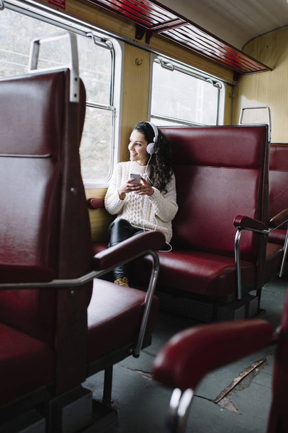 Teen passenger listening to the music traveling in a train - Valokuva, kuva
