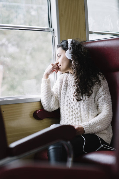 Έφηβος επιβατών ακούτε τη μουσική που ταξιδεύουν σε ένα τρένο - Φωτογραφία, εικόνα