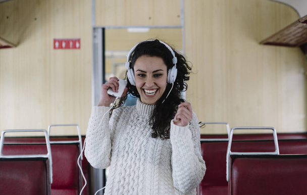 Tiener passagier luisteren naar de muziek reizen in een trein - Foto, afbeelding