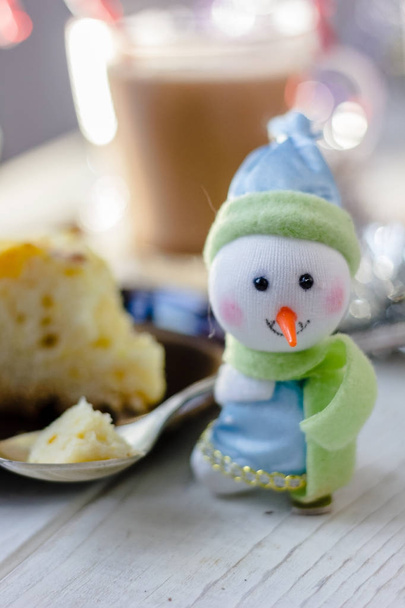 Christmas snowman holding metal spoon with the piece of christmas pie. - Photo, Image