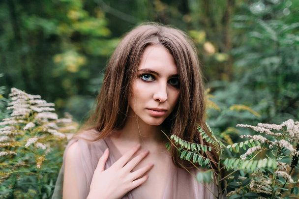 Portrait of beautiful caucasian girl in green leaves. Soft focus - Foto, Bild