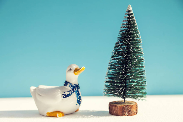 christmas tree and porcelain duck on blue background - Фото, зображення