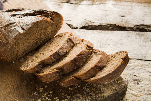 Sliced homemade brown bread on a cutting board. - Valokuva, kuva