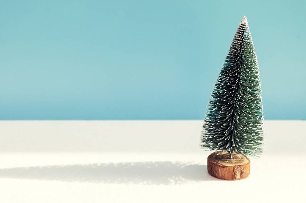 Χριστουγεννιάτικο χιονισμένο δέντρο σε μπλε φόντο - Φωτογραφία, εικόνα