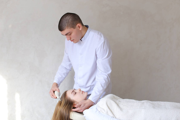 Stately male male cosmetologist makes head massage with special - Photo, Image