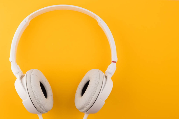 άσπρα ακουστικά σε κίτρινο φόντο - Φωτογραφία, εικόνα