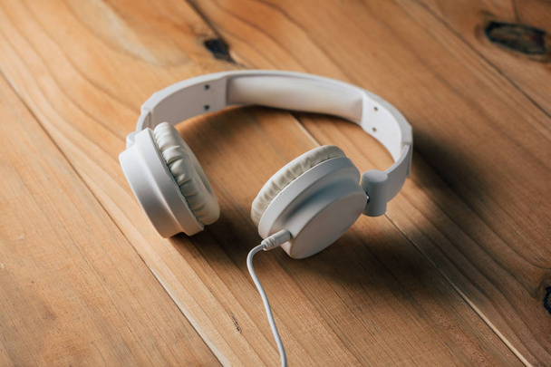 białe słuchawki na drewnianym stole - Zdjęcie, obraz