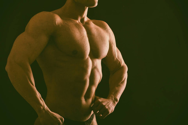 Muscular, levantador de pesas en relieve sobre un fondo negro
 - Foto, Imagen