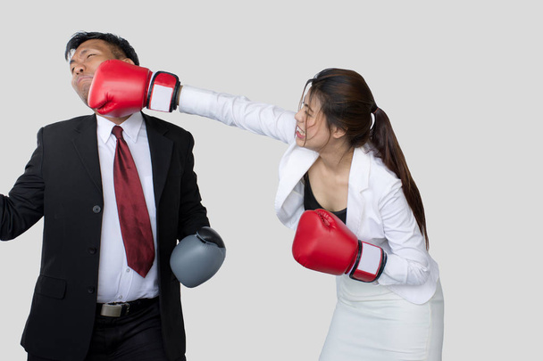 Portrait d'une femme d'affaires professionnelle en costume et gants de boxe donnant un coup de pied à son rival
 - Photo, image