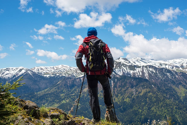 Adventurer, with backpack, stands on the mountain top  - Foto, immagini