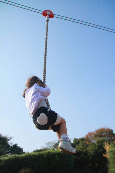Ιαπωνικά κορίτσι (3 ετών) παίζει με flying fox - Φωτογραφία, εικόνα