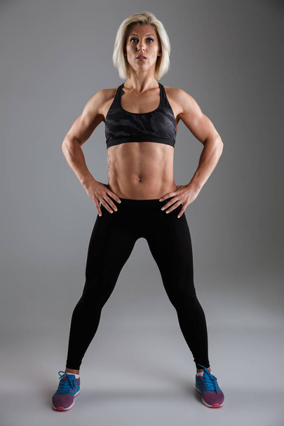 Full length portrait of a confident muscular adult sportswoman - Фото, изображение