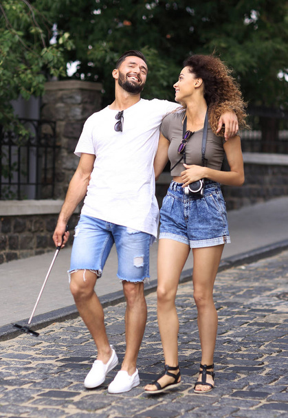 Fröhliches junges Paar läuft auf Stadtstraße - Foto, Bild