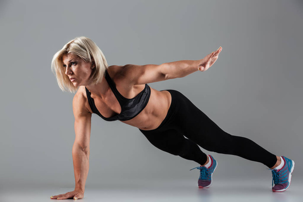 Portrait of a concentrated muscular adult sportswoman - Fotografie, Obrázek