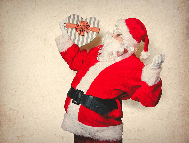 Санта Клаус тримає подарункову коробку
 - Фото, зображення