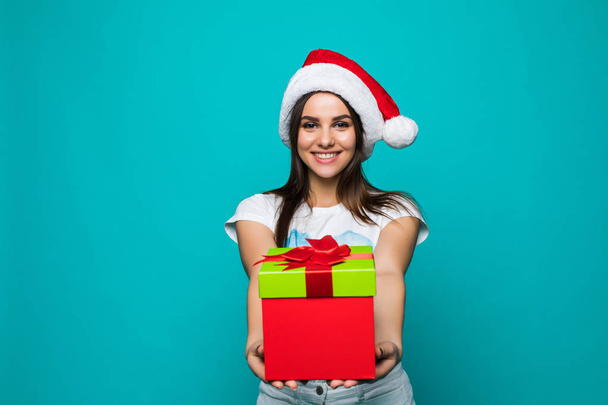 クリスマス ギフト ボックスと女性。サンタ帽子の美しいブルネットの少女は、色の背景上分離されました。肖像画 - 写真・画像