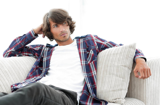 serious modern guy sitting on the couch - Photo, Image