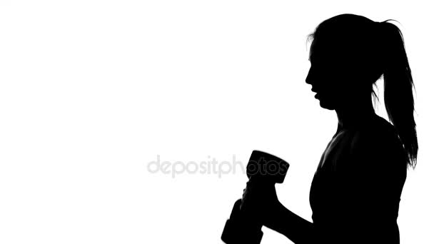 on a white background, a shadow, a black outline of a female figure doing exercises for the muscles of the hands, using dumbbells - Video