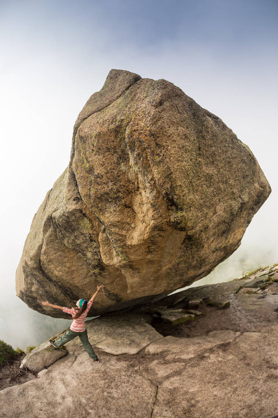 Bergsteiger ist Bouldern in der Natur. Mädchen klettert auf einen großen Stein. Frau beim Sport im Freien. Sportler treibt Sport im Freien. - Foto, Bild
