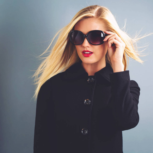 Beautiful blonde woman in a black coat - 写真・画像