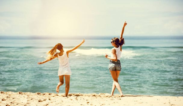 Δύο κορίτσια ευτυχισμένη θάλασσα παραλία διασκέδαση - Φωτογραφία, εικόνα