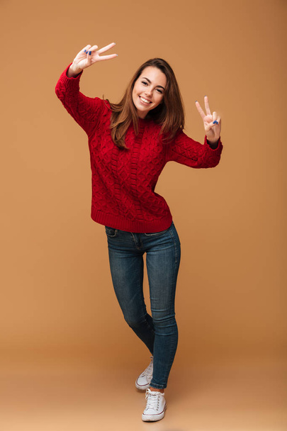 Full length portrait of young funny girl in casual wear showing  - Foto, afbeelding