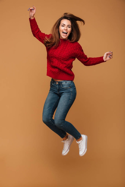 Full length portrait of happy young woman in red knitted sweater - Photo, image