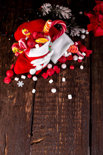 クリスマス ソックス キャンディと木製の背景にお菓子いっぱい. - 写真・画像