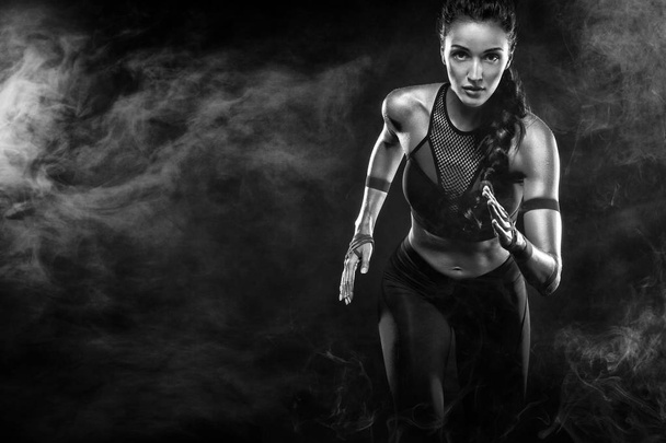 A strong athletic, woman sprinter, running on black background wearing in the sportswear, fitness and sport motivation. Runner concept with copy space. - 写真・画像