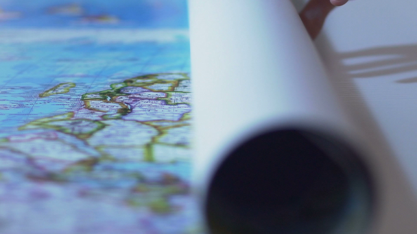 Человек разворачивает карту мира на столе, туристический маршрут для отдыха за границей
 - Кадры, видео