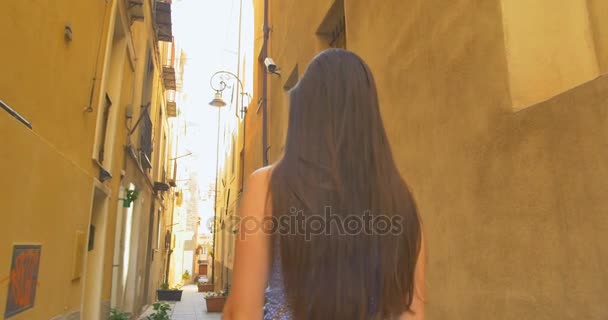 Joven turista mujer caminando por la pequeña calle en un día soleado. Chica pasar vacaciones en Europa, explorar el casco antiguo medieval
. - Imágenes, Vídeo