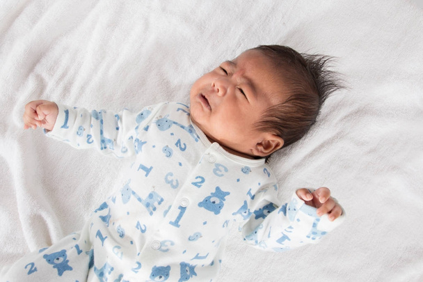Милий азіатський новонароджений плаче на білому рушнику
 - Фото, зображення