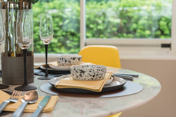 tavola apparecchiata su tavolo rotondo con sedia gialla
 - Foto, immagini
