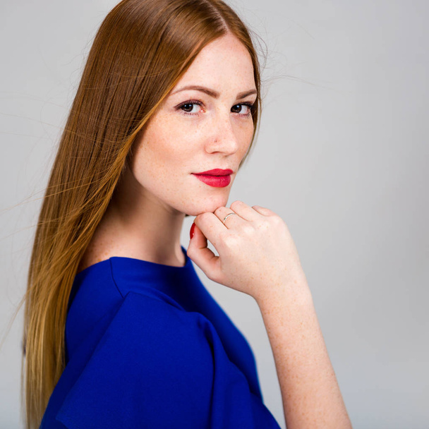 Ritratto di una bella giovane donna dai capelli rossi. Ragazza sorridente su uno sfondo grigio
 - Foto, immagini