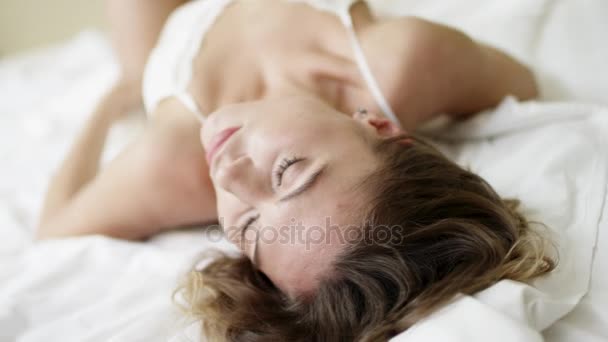 Zoete jonge vrouw lijnen haar borst en benen op bed - Video