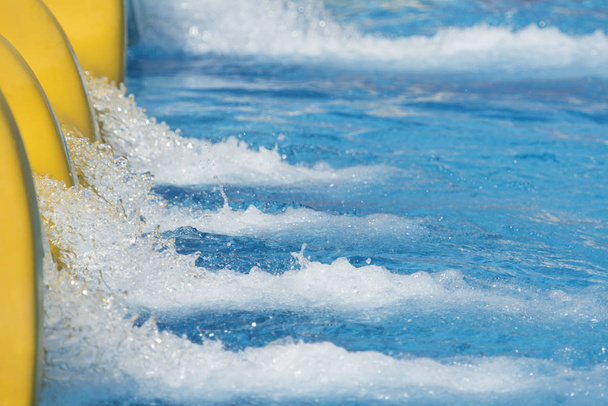 スイミング プールのスライドから水のしぶき - 写真・画像