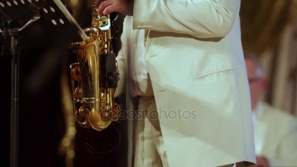 Saxofonista v bílém obleku hraje na saxofon sólo. - Záběry, video