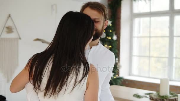 Happy attractive young couple in love dance together in their stylish apartment by the christmas tree - Imágenes, Vídeo