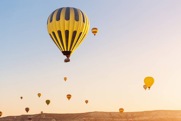 Sok hőlégballonok repül: Cappadocia rock táj napkeltekor kora reggel - Fotó, kép