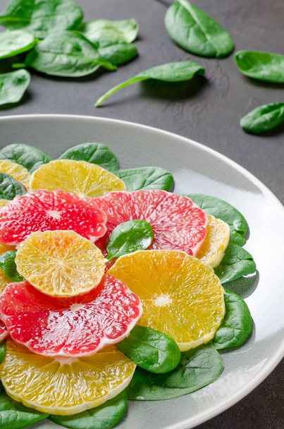 Salade gemaakt van sinaasappel- en grapefruitsap segmenten en spinazie bladeren op - Foto, afbeelding