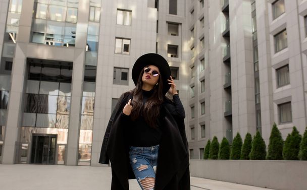 Portrait de rue du modèle à la mode en manteau noir tendance et st
 - Photo, image