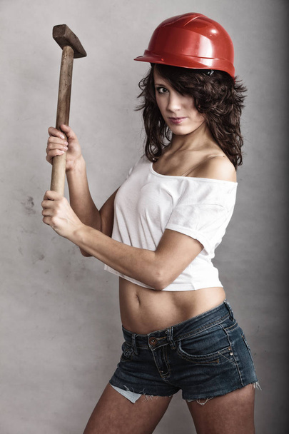 Sexy girl in safety helmet holding hammer tool - Фото, изображение