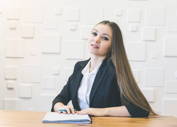 beautiful long-haired successful girl in suit sitting in office, working - 写真・画像