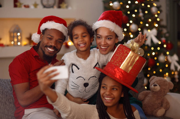 Christmas lovely afro American family making selfie - 写真・画像