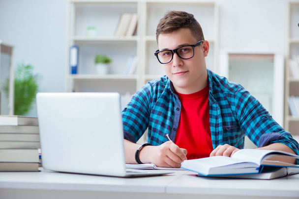 Junger Teenager bereitet sich am Schreibtisch im Haus auf Prüfungen vor - Foto, Bild