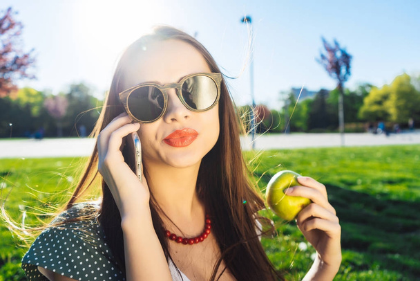 Pretty woman with mobile phone,outdoor.Girl in glasses - Foto, Imagen