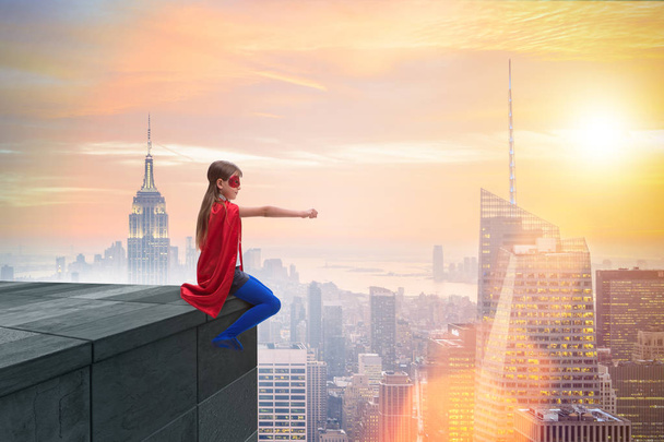 Chica joven en traje de superhéroe con vistas a la ciudad - Foto, imagen